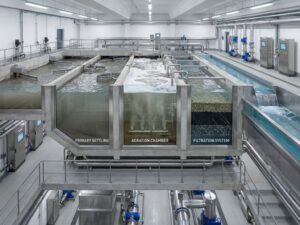 Querschnitt einer modernen Kläranlage mit mehrstufigen Behandlungssystemen, Klärbecken und gereinigtem Wasser