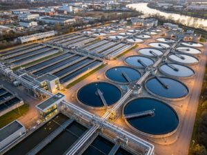 Luftaufnahme von Deutschlands größter Kläranlage mit kreisförmigen Klärbecken und rechteckigen Absetzbecken